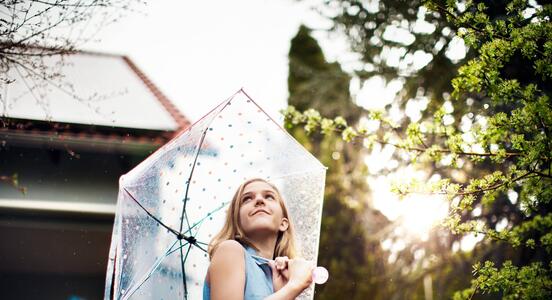Aurinkopaneelit katolla - tyttö sateenvarjon alla