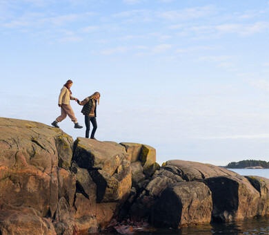 Kaksi naista kalliolla rauhallisen meren äärellä