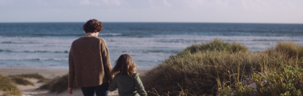 Mies ja lapsi kävelee rantaa kohden